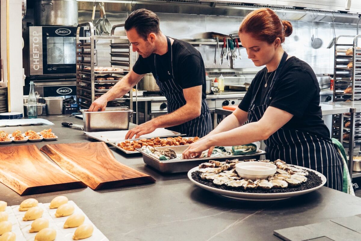 Deux cuisiniers en action dans la cuisine d un restaurant